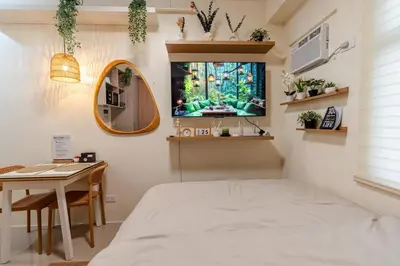 a bedroom with a bed and a fish tank on the wall at SSM Staycation in Manila