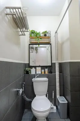 a bathroom with a toilet with plants on the wall at SSM Staycation in Manila