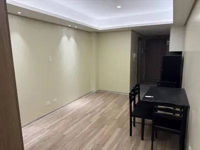 a room with a table and chairs and a television at Condotel by Heidi in Manila