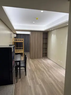 a dining room with a table and a desk in a room at Condotel by Heidi in Manila
