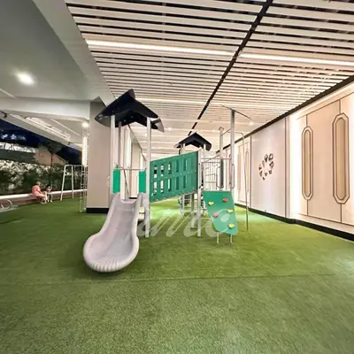 a room with a playground with a slide and chairs at A Space Close to Transits or Airport in Manila