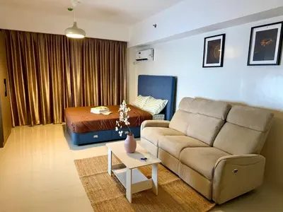 a living room with a couch and a bed at pocco homestay in Manila