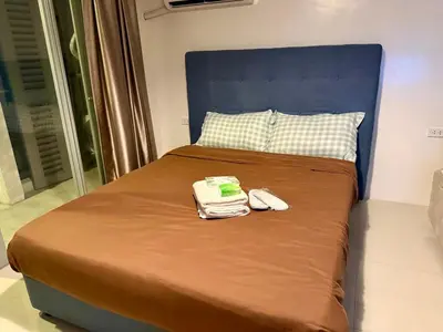 a bed with a blue headboard and two phones on it at pocco homestay in Manila