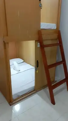 a small room with a bunk bed and a ladder at Capsule88 Hotel in Manila
