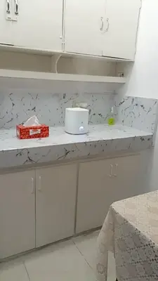 a kitchen counter with white cabinets and a box on it at Capsule88 Hotel in Manila
