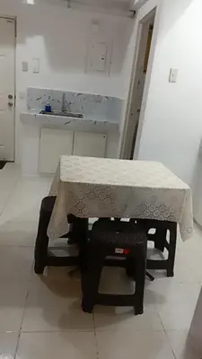 a table and chairs in a room with a counter at Capsule88 Hotel in Manila