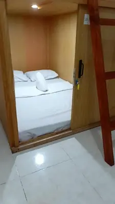 a room with two beds and a door with a computer mouse at Capsule88 Hotel in Manila