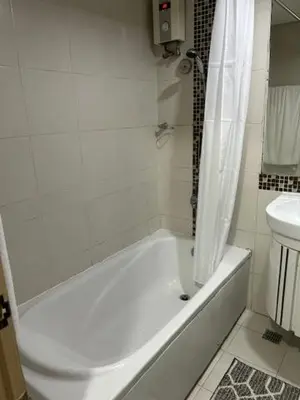 a white bathroom with a tub and a toilet at Solemare Parksuites - no balcony in Manila