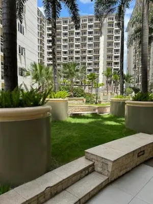 a park with palm trees and benches and buildings at Solemare Parksuites - no balcony in Manila