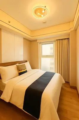 a bedroom with a large bed with a window at Spacious 5-Bedroom Luxury Apartment Across Okada in Manila
