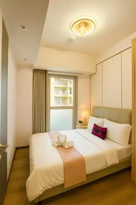 a bedroom with a large white bed with a window at Spacious 5-Bedroom Luxury Apartment Across Okada in Manila