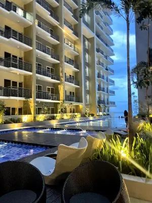 a resort with a swimming pool and two chairs at Luxury 1-Bedroom Apartment Across Okada Manila in Manila
