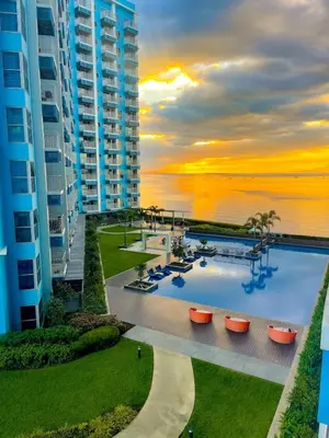a view of a resort with a pool and the ocean at Luxury 1-Bedroom Apartment Across Okada Manila in Manila