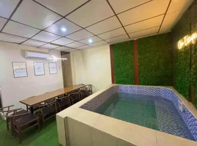 a room with a swimming pool in a room with a table and chairs at Cozy Villa with Pool for family or couples in Bacoor