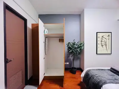 a bedroom with a bed and a closet and a door at Spacious 1BR with 300MBPS Internet near High Street BGC in Manila