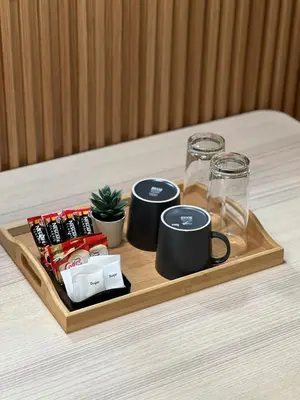a wooden tray with cups and drinks on a table at Spacious 1BR with 300MBPS Internet near High Street BGC in Manila