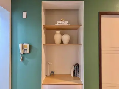 a book shelf with two vases on it in a room at Spacious 1BR with 300MBPS Internet near High Street BGC in Manila