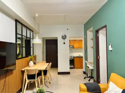 a kitchen and living room with a table and chairs at Spacious 1BR with 300MBPS Internet near High Street BGC in Manila