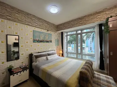 a bedroom with a bed and a large window at Marvinn's by LVH - 150 Newport Boulevard in Manila