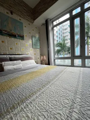 a bedroom with a large bed with a large window at Marvinn's by LVH - 150 Newport Boulevard in Manila