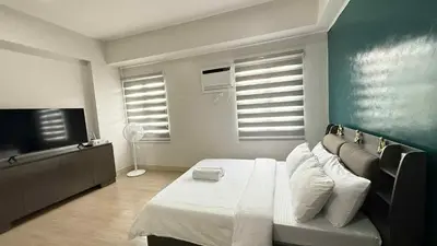 a bedroom with a bed and a flat screen tv at Condo near SM City Sta Rosa unit 4 in Ibaba