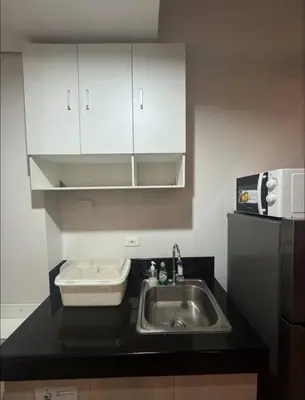 a kitchen with a sink and a microwave at Condo near SM City Sta Rosa unit 4 in Ibaba