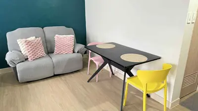 a living room with a couch and a table and chairs at Condo near SM City Sta Rosa unit 4 in Ibaba