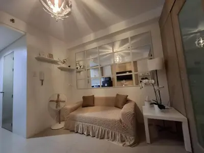 a bedroom with a bed and a table in a room at Sam's crib staycation in Manila