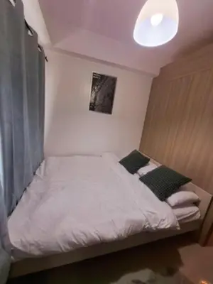 a bed in a small room with a light at Sam's crib staycation in Manila
