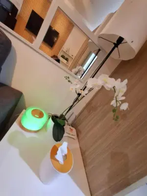 a vase with flowers on a table in a room at Sam's crib staycation in Manila