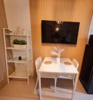 a white table and chairs in a room with a tv at Sam's crib staycation in Manila