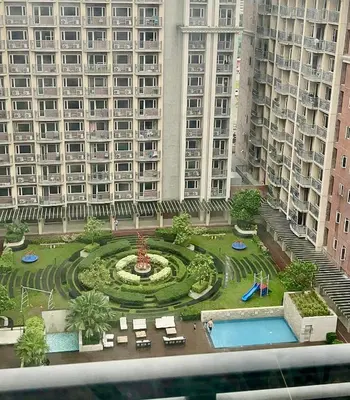 a view of a large building with a garden in front at Condo Monarch Parksuites in Sampong