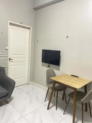 a room with a table and chairs and a television at Condo Monarch Parksuites in Sampong