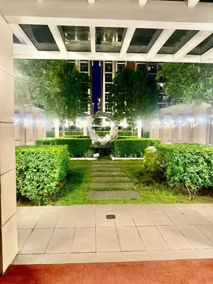 a view of a garden at night with lights at Condo Monarch Parksuites in Sampong