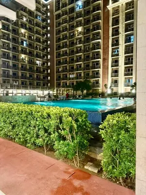 a large swimming pool in front of a large building at Condo Monarch Parksuites in Sampong