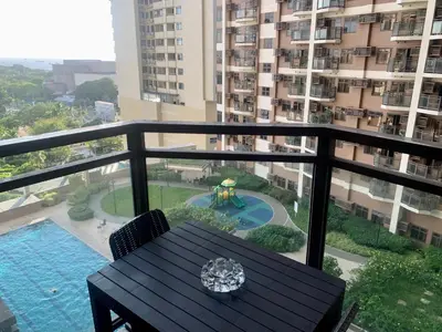 a balcony with a table and a view of a building at Manila Bay Condo in Manila