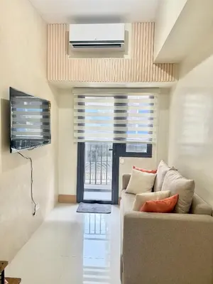 a living room with a couch and a window at Soléa Suites in Manila