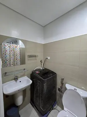 a bathroom with a white toilet and a sink at Amazing view in Shore 2 Residences by Richnells in Manila