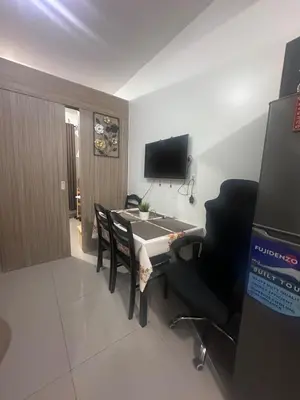 a room with a table and chairs and a television at Amazing view in Shore 2 Residences by Richnells in Manila