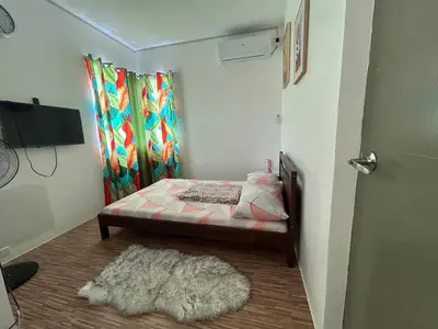a small bedroom with a bed and a rug at Norene Bianca Staycation in Carmona