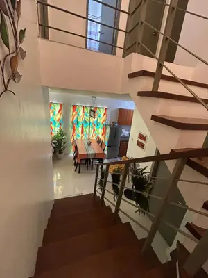 a staircase leading to a living room and a dining room at Norene Bianca Staycation in Carmona