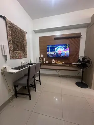 a living room with a desk and a tv and a table at Shore 2 tower 1 by Richnells cozy Oasis in Manila