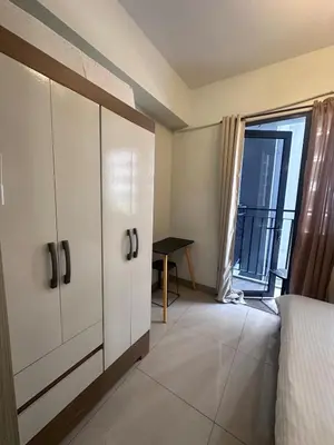 a bedroom with a bed and a window with a desk at Shore 2 tower 1 by Richnells cozy Oasis in Manila