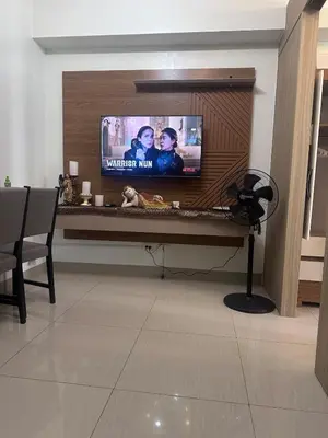 a living room with a flat screen tv on a wall at Shore 2 tower 1 by Richnells cozy Oasis in Manila
