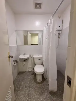 a white bathroom with a toilet and a sink at Flat 35, Unit 1C in Manila