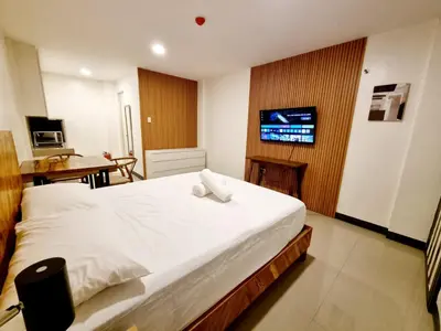 a bedroom with a bed and a desk and a television at Flat 35, Unit 1C in Manila