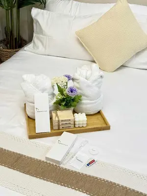 a tray with towels and flowers on a bed at Azure residences by Amóre Suites in Manila