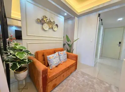 a living room with a brown couch and a plant at Jazz Haven Makati in Manila