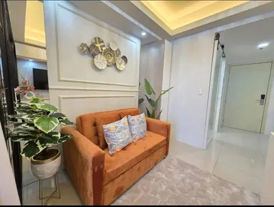 a brown couch with two pillows in a living room at Jazz Haven Makati in Manila