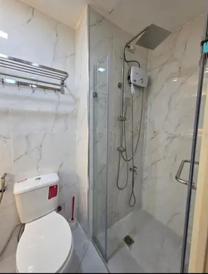 a bathroom with a toilet and a glass shower at Jazz Haven Makati in Manila